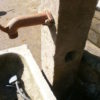 historischer Brunnen mit Sandsteintrog und antiker Stele
